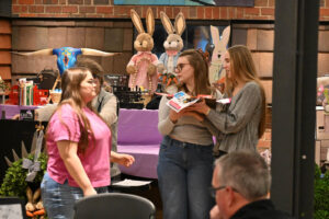 New Lexington High School volunteer auction assistants Chloe, Rosalee, and Catlyn during the Live Auction at the 2026 EHFAR For the Love of Kids Fundraiser.