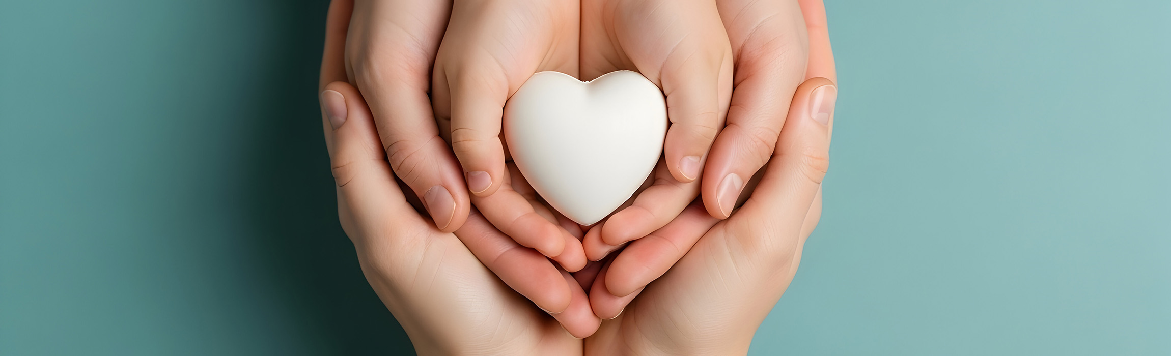 Hands cupped around white clay heart