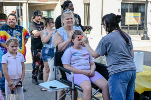 Child getting her face painted by Liv Hammer on Main Street in New Lexington during the 2026 Chalk It Up to Summer event for kids and families.