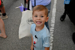 Child smiling on Main Street in New Lexington during the 2026 Chalk It Up to Summer event for kids and families.