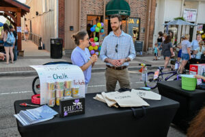 Volunteers manning the chalk booth on Main Street in New Lexington during the 2026 Chalk It Up to Summer event for kids and families.