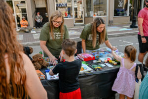Volunteers from Big Brothers Big Sisters of Licking and Perry Counties hand out prizes on Main Street in New Lexington during the 2026 Chalk It Up to Summer event for kids and families.