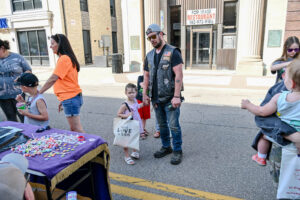A father and daughter on Main Street in New Lexington during the 2026 Chalk It Up to Summer event for kids and families.