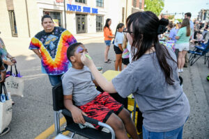 Child having his face painted on Main Street in New Lexington during the 2026 Chalk It Up to Summer event for kids and families.