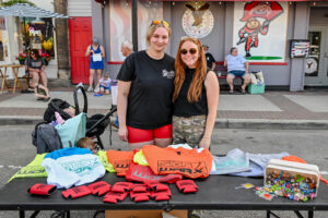 SignWorx team at their giveaway table on Main Street in New Lexington during the 2026 Chalk It Up to Summer event for kids and families.