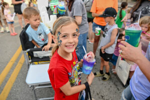 Face-painted child on Main Street in New Lexington during the 2026 Chalk It Up to Summer event for kids and families.