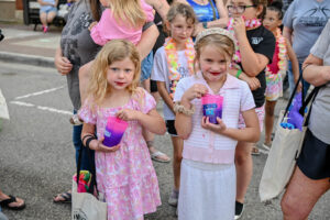 Two girls enjoying KONA Ice on Main Street in New Lexington during the 2026 Chalk It Up to Summer event for kids and families.
