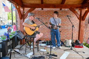Guitarists Mike and Elliot Boley playing together on patio at Trotter's on Main Street in New Lexington during the 2026 Chalk It Up to Summer event for kids and families.